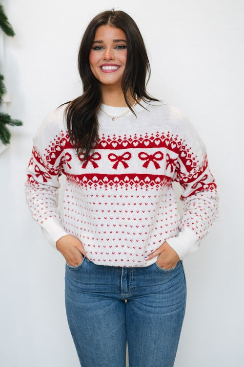 ivory holiday sweater with red bow pattern