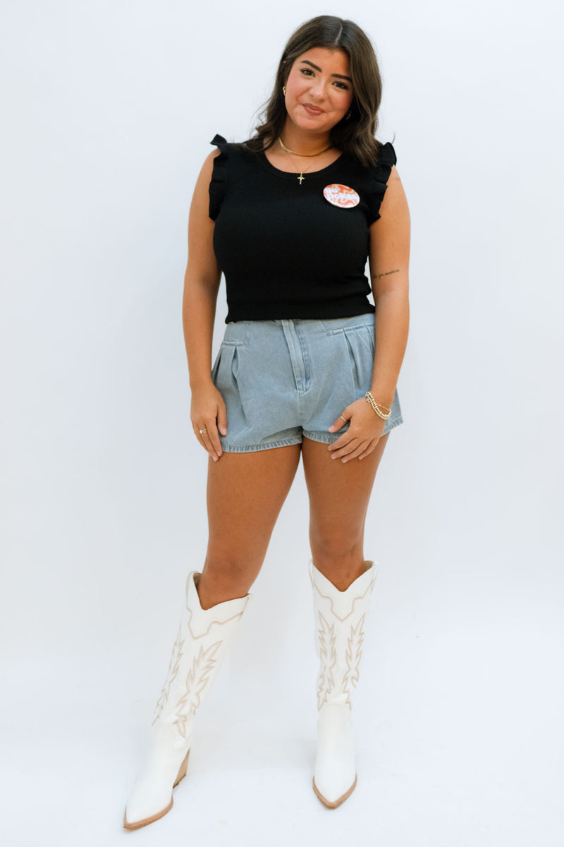 Black top with denim shorts and white tall boots for game day