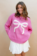 cute pink sweater with white bow in it stitched hem